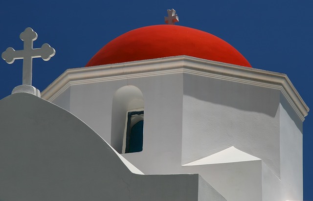 chiesa bianca con tetto rosso in stile greco con croce sulla cupola