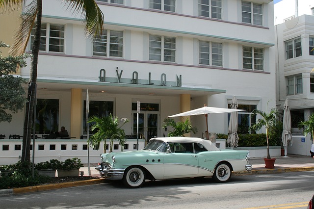 auto d'epoca di fronte ad un hotel con il nome riportato sopra l'ingresso