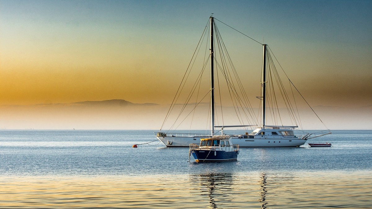 una barca a vela ferma in mare al tramonto